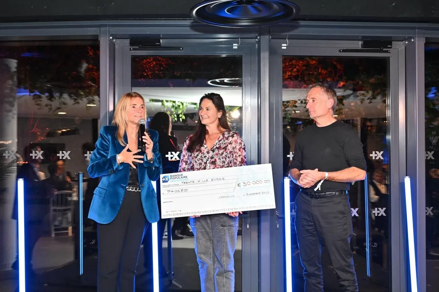 Deux invités posent entre le kakémono des missions de Phoceo et celui de la Banque Populaire Méditerranée.