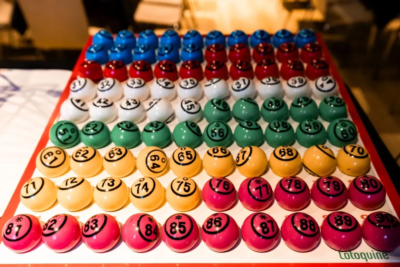 Les quatre-vingt-dix boules numérotées du loto, rangées par couleur sur leur plateau.